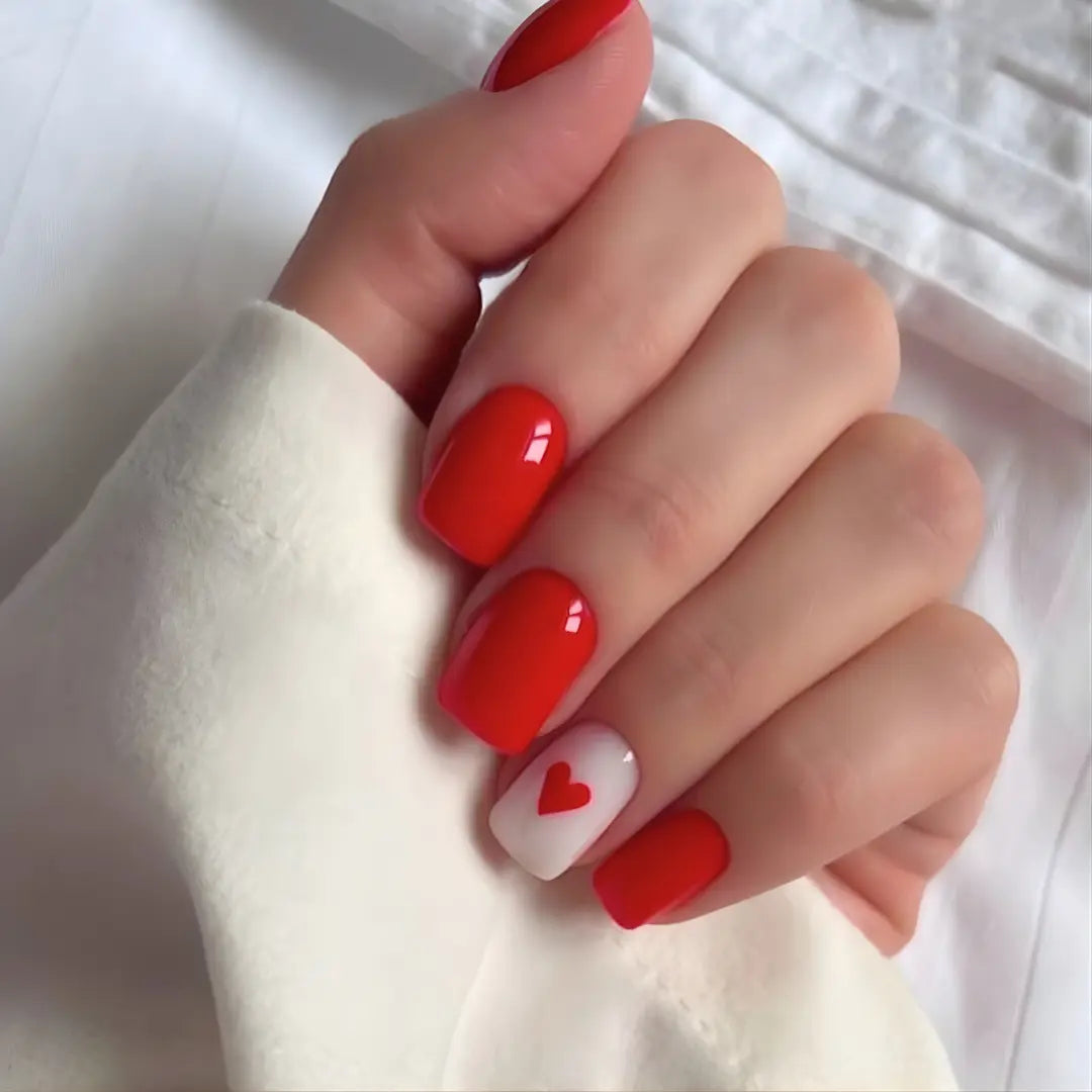 Short solid red nails with a heart accent by Soul Struck