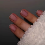 Short nude pink press-on nails with silver glitter French tips in a glossy salon-style manicure