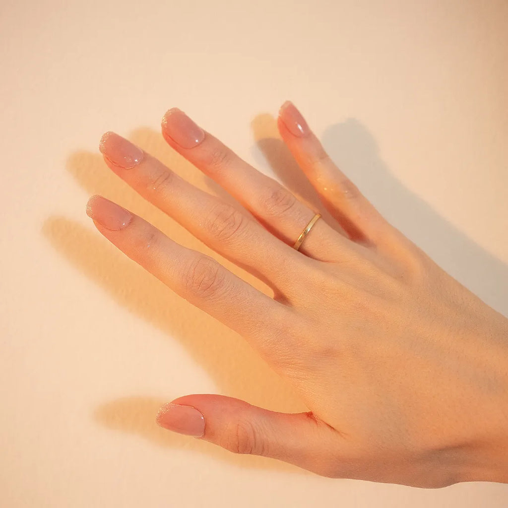 Short nude pink press-on nails with silver glitter French tips in a glossy salon-style manicure by Soul Struck