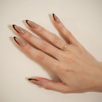 Long almond-shaped nude taupe press-on nails with dark brown angled French tips